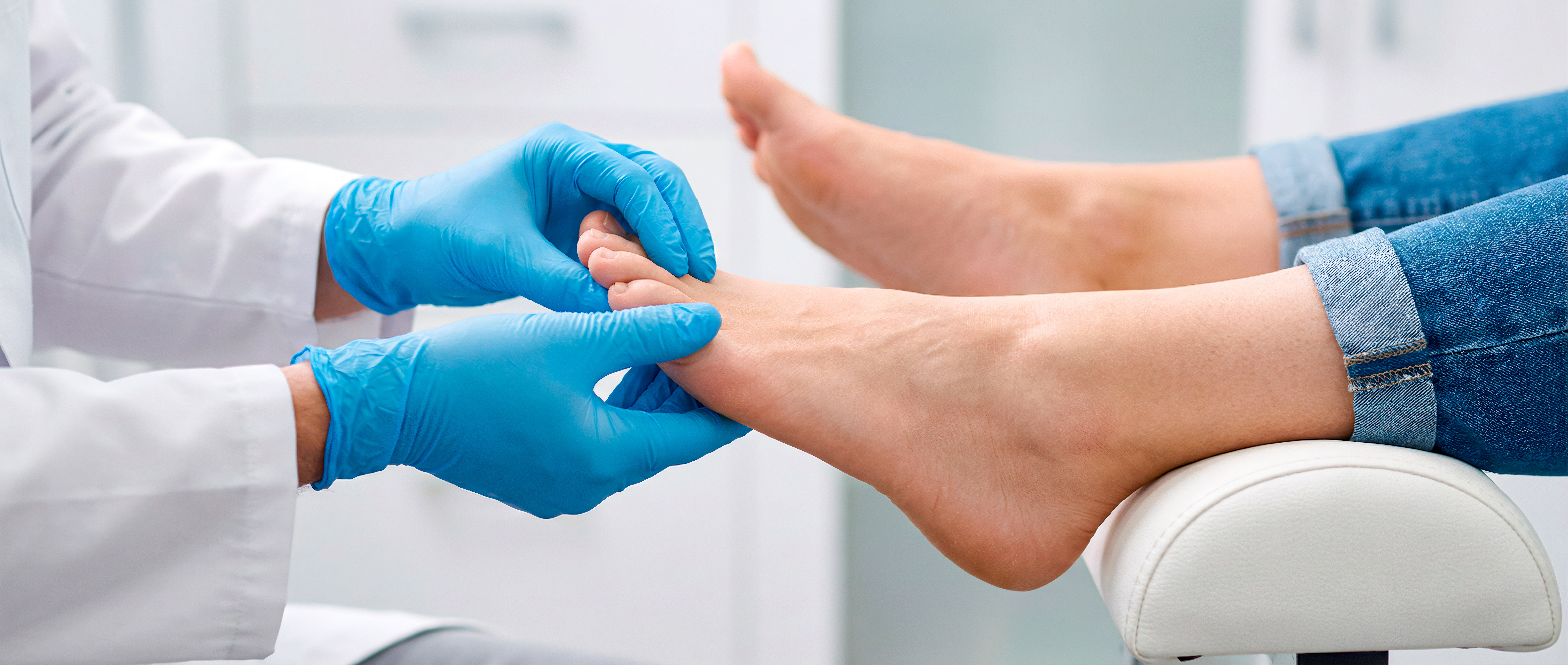 Clinician examining a patient's foot in a clinical setting